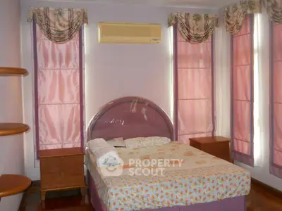 Cozy bedroom with elegant drapes and air conditioning, perfect for restful nights.