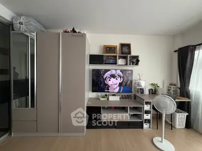 Modern living room with sleek storage, TV, and natural light