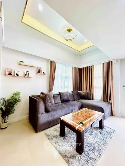 Modern living room with plush gray sofa, elegant coffee table, and stylish decor in bright natural light.