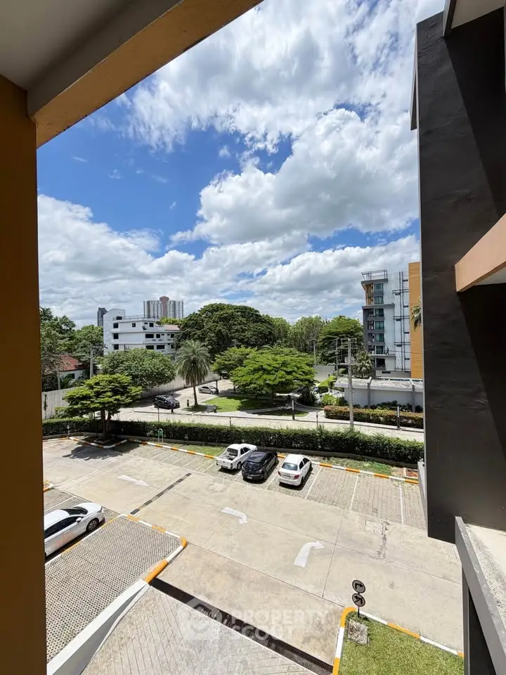 Stunning view from a modern apartment balcony overlooking lush greenery and urban landscape.