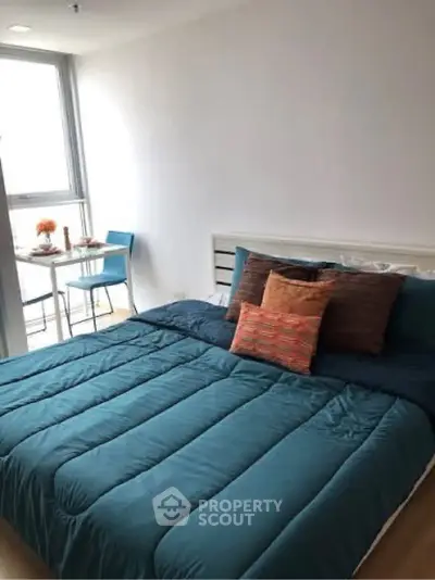 Cozy bedroom with modern decor and natural light, perfect for relaxation.