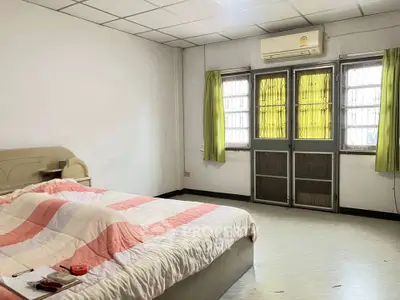 Spacious bedroom with cozy bed and natural light from large windows