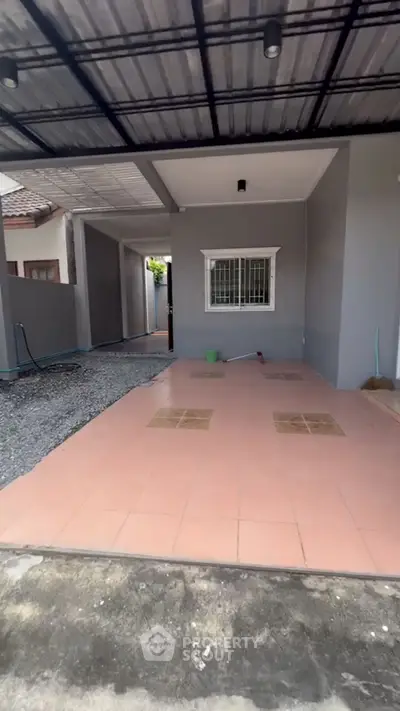 Charming exterior view of a modern home with tiled patio and covered carport.