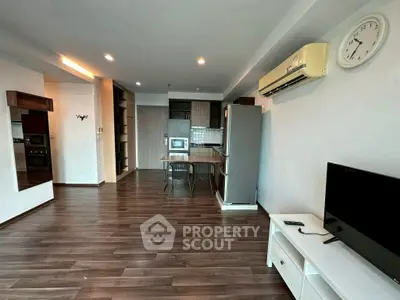 Spacious modern living room with open kitchen and sleek wooden flooring