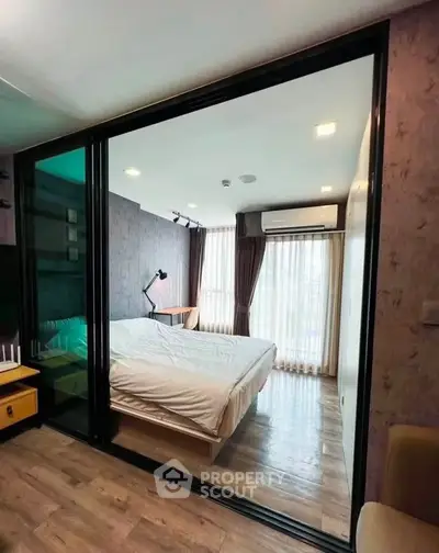 Modern bedroom with glass partition and natural light, featuring stylish decor and cozy ambiance.