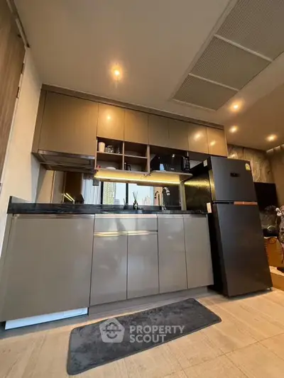 Modern kitchen with sleek cabinets and stainless steel appliances in a stylish apartment.