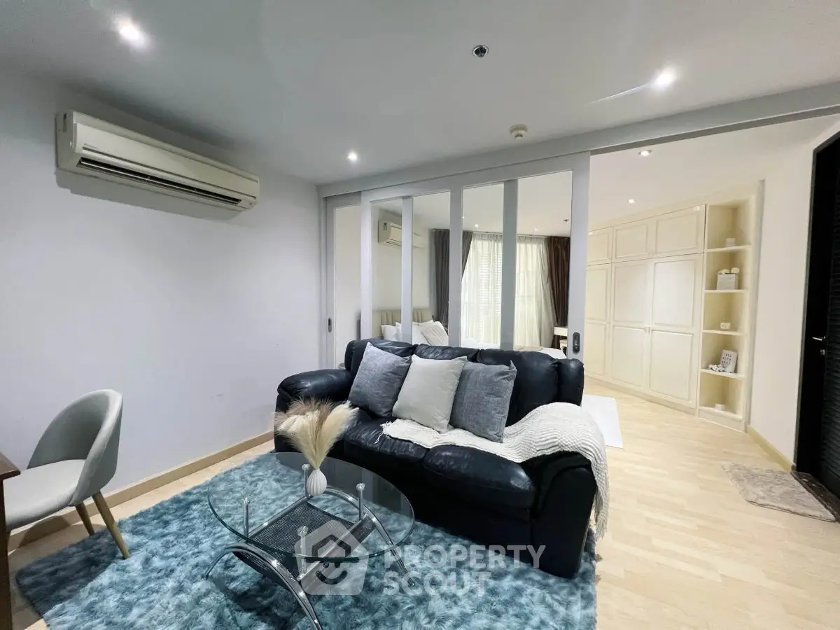 Modern living room with sleek design, featuring a cozy sofa, glass coffee table, and stylish decor.