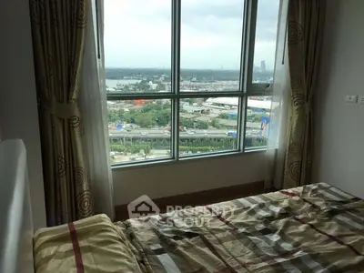 Cozy bedroom with large window offering stunning cityscape view