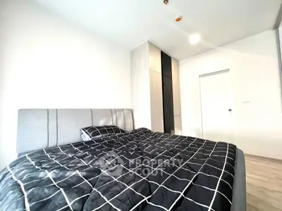 Modern bedroom with stylish black and white bedding and sleek wardrobe.