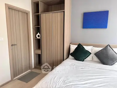 Modern bedroom with stylish decor and built-in wardrobe, featuring a cozy bed and elegant wall art.