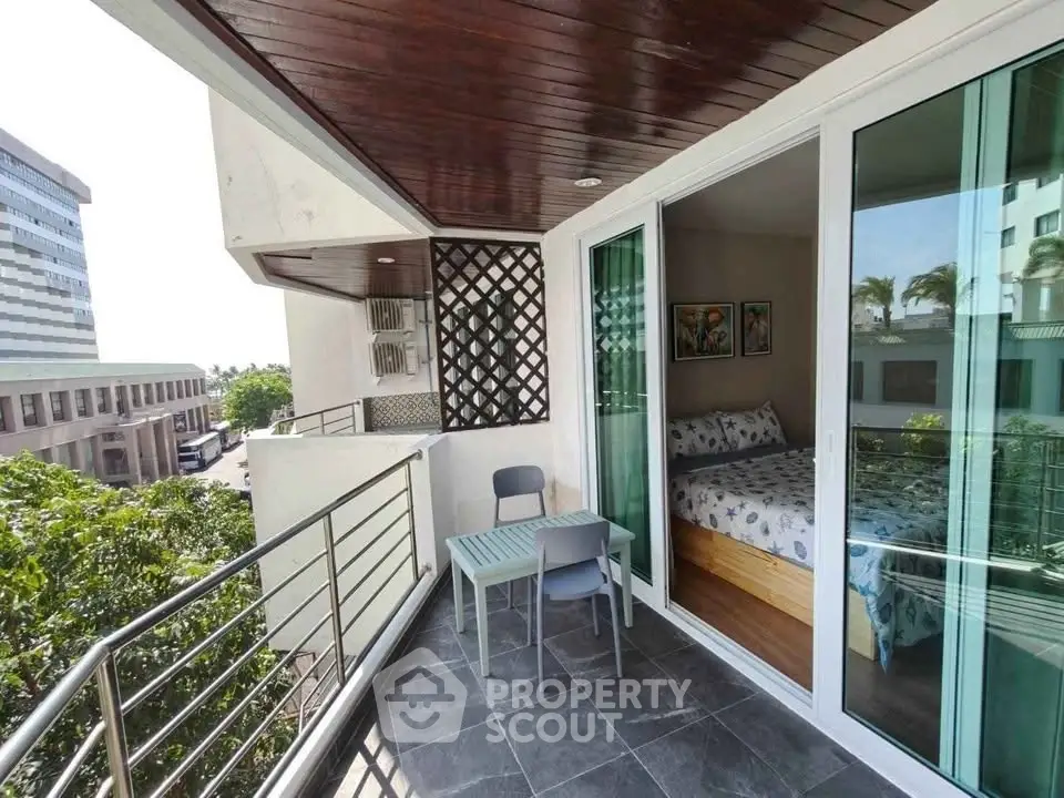 Charming balcony with city view and cozy bedroom access in modern apartment