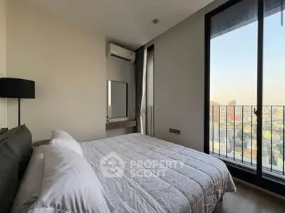 Modern bedroom with city view and balcony access in a high-rise apartment.