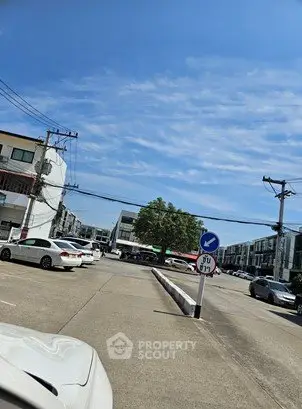 Spacious parking area in a modern residential complex with clear blue skies.