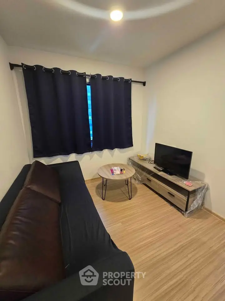 Cozy living room with modern sofa, TV, and stylish coffee table, perfect for relaxation.