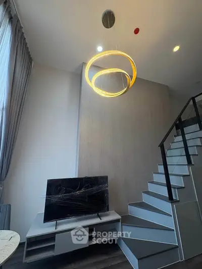 Modern living room with stylish staircase and elegant lighting fixture