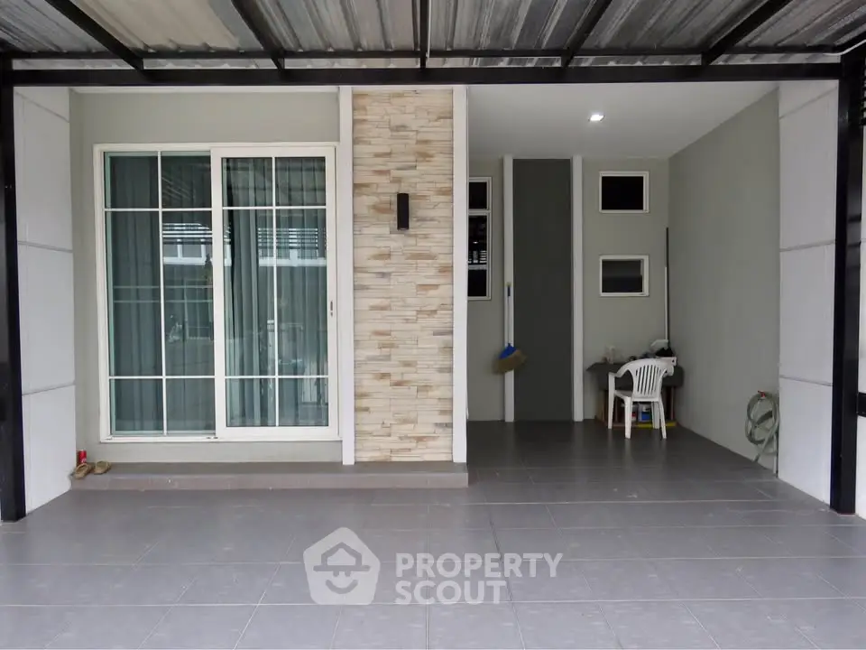Modern home entrance with sliding glass doors and tiled patio