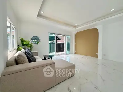 Spacious modern living room with elegant marble flooring and large windows for natural light.