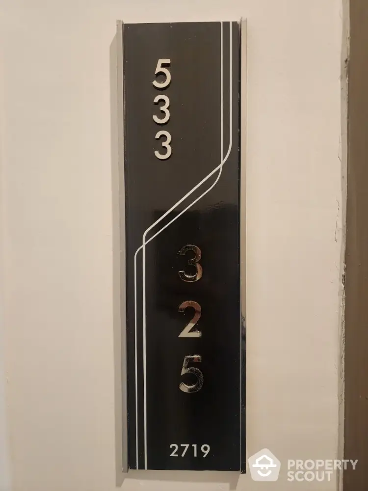 Stylish modern apartment number plaque with sleek design and bold numerals.