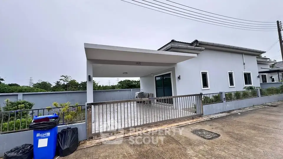 Modern single-story house with spacious driveway and sleek exterior design.