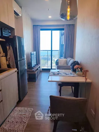 Modern apartment with open layout, featuring a cozy living area and stunning city view from the balcony.