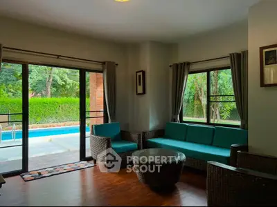 Spacious living room with pool view and modern wicker furniture
