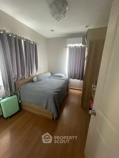 Cozy bedroom with wooden flooring and natural light