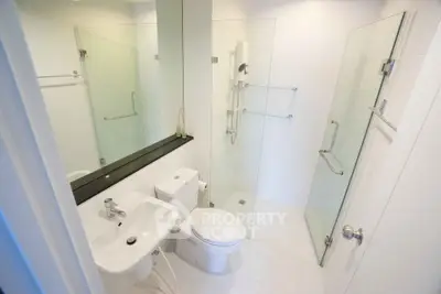 Modern bathroom with glass shower and sleek fixtures in a contemporary home.