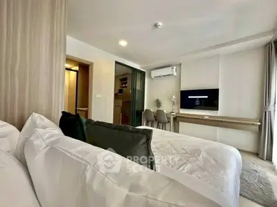 Modern bedroom with stylish decor and wall-mounted TV in a cozy apartment.