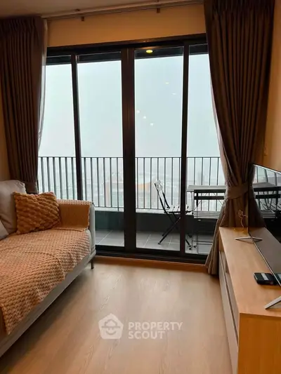 Modern living room with balcony view, cozy sofa, and stylish decor