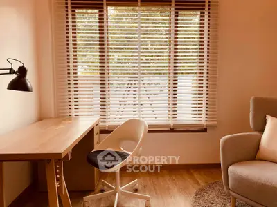 Cozy study room with modern desk, chair, and large window with blinds.