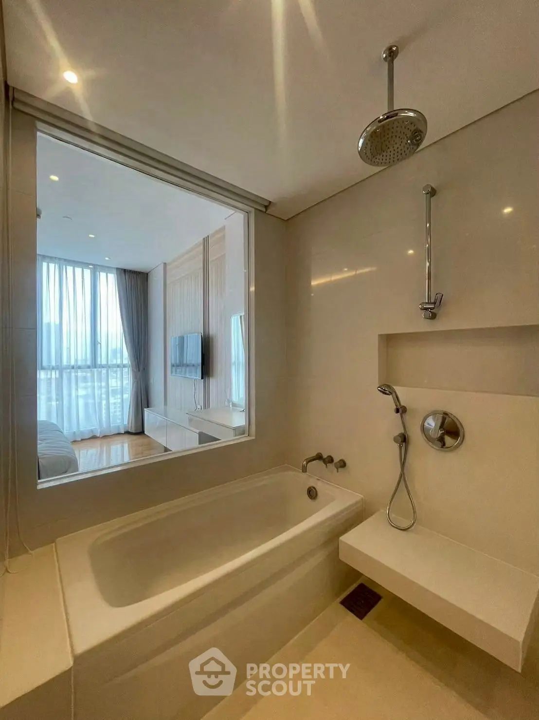 Modern bathroom with bathtub and view into stylish bedroom