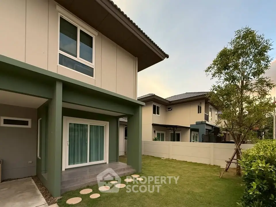 Modern two-story house with spacious garden and elegant exterior design.