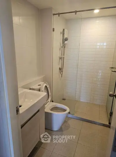Modern bathroom with glass shower and sleek fixtures in a contemporary apartment.
