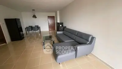 Spacious living room with modern gray sofa and dining area