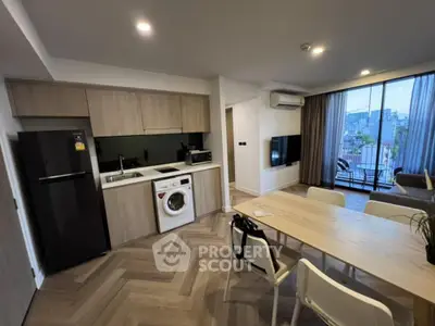 Modern open-layout kitchen and living area with city view balcony.