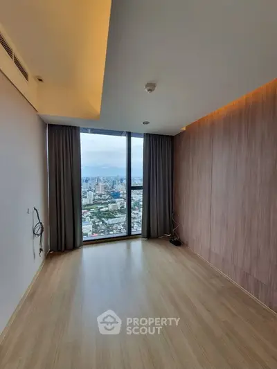 Spacious empty room with large window offering stunning city view, perfect for customization.