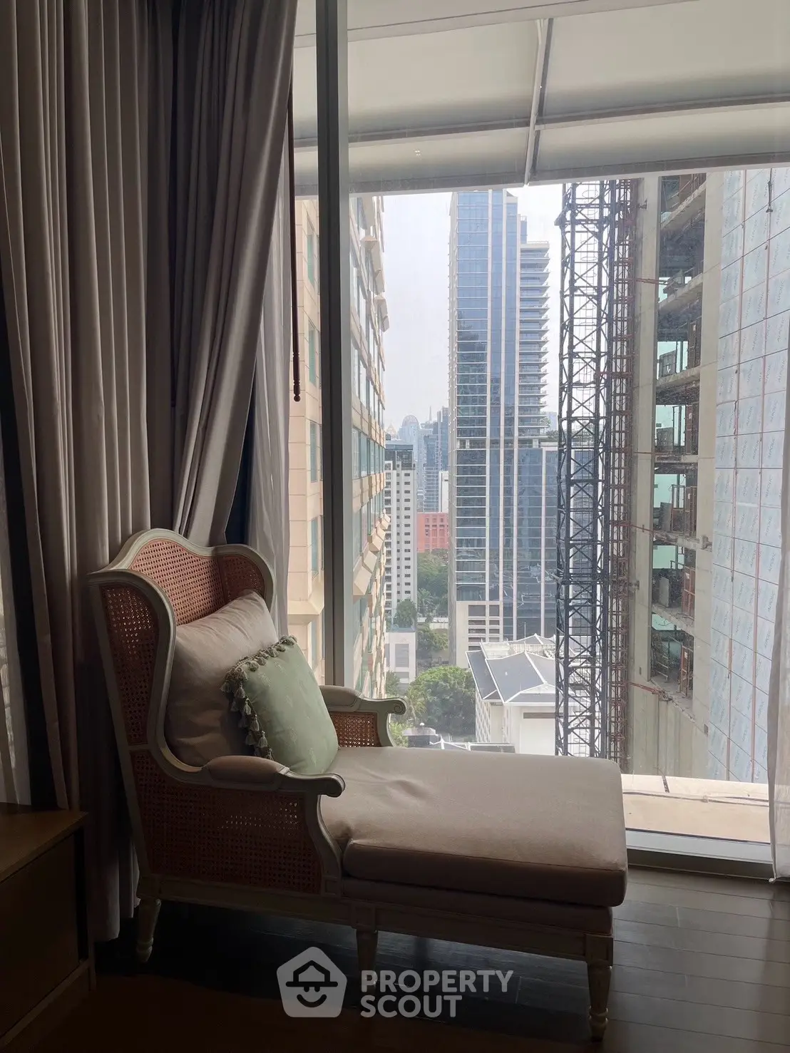 Luxurious high-rise apartment with stunning city view from a cozy reading nook.