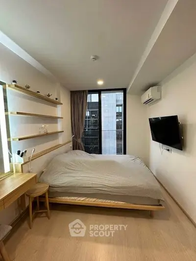 Modern bedroom with minimalist design and large window for natural light.