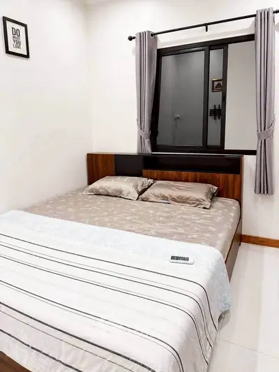 Cozy bedroom with modern decor and large window, perfect for relaxation and comfort.