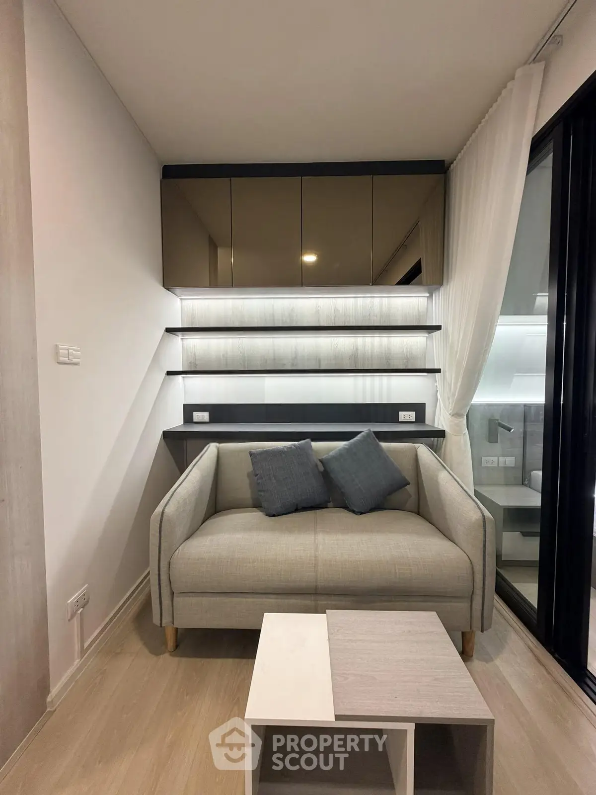 Modern living room with stylish sofa and sleek shelving in a cozy apartment setting.