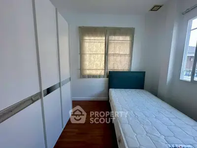 Cozy bedroom with natural light, featuring a single bed and modern wardrobe.
