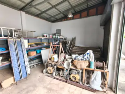Spacious storage area with metal shelves and construction materials, ideal for workshop or warehouse use.