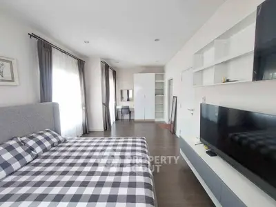 Spacious modern bedroom with stylish decor and ample natural light