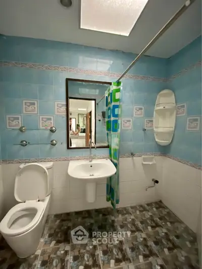 Spacious bathroom with modern fixtures and vibrant blue tiles, perfect for a refreshing start to your day.