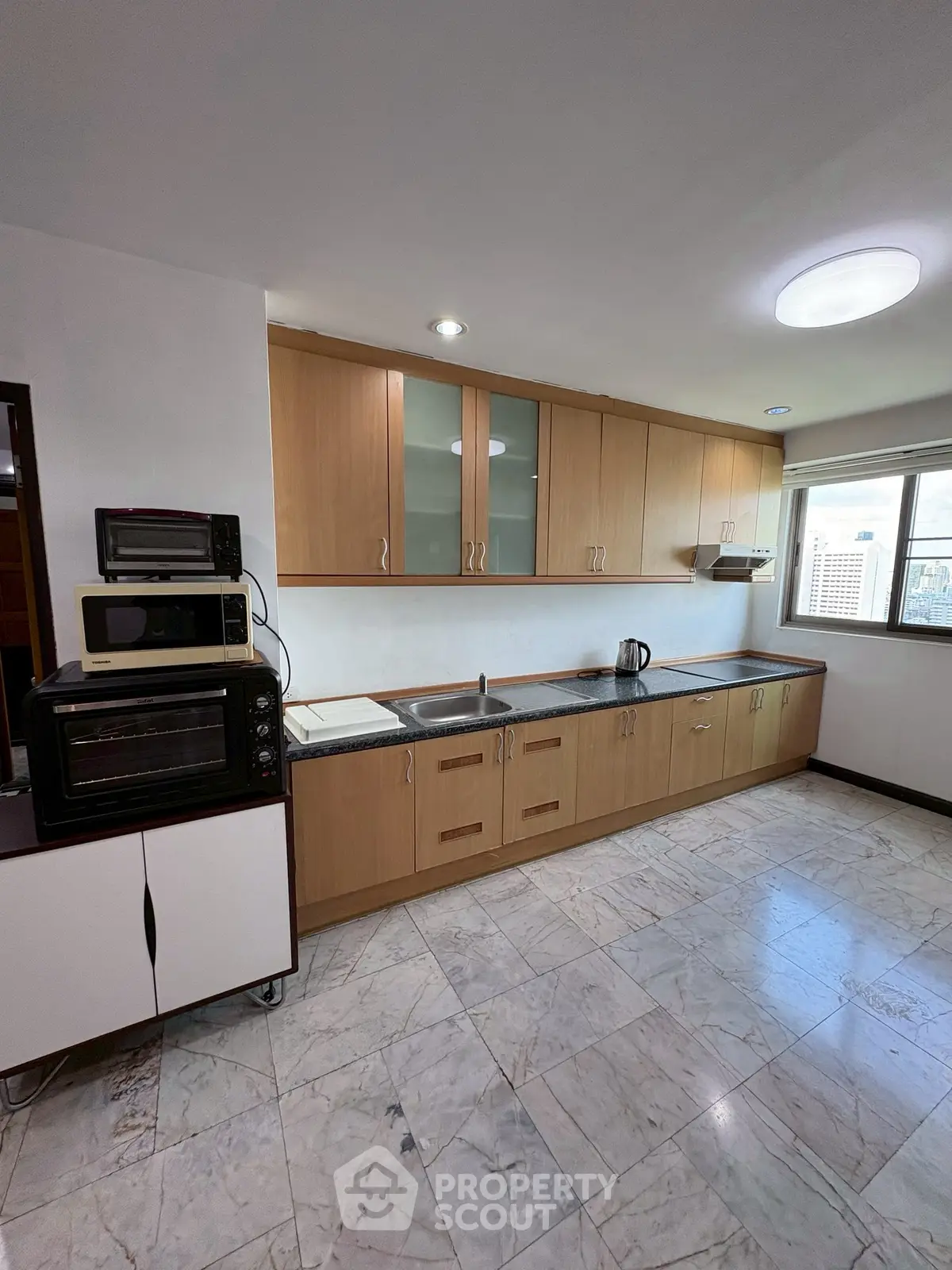 Spacious kitchen with modern appliances and ample storage in a bright apartment.