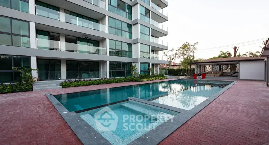 Modern apartment building with luxurious outdoor pool and spacious deck area.
