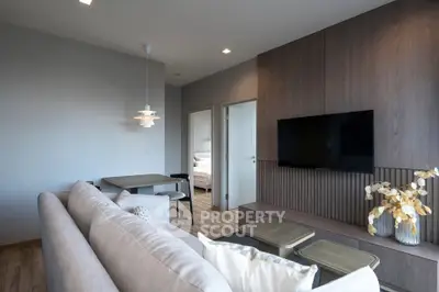 Modern living room with stylish decor and open view to bedroom