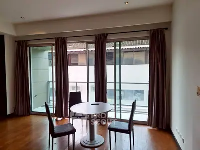 Spacious living room with large windows and balcony access in modern apartment.