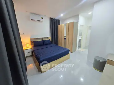 Modern bedroom with sleek design, featuring a comfortable bed, stylish wardrobe, and ambient lighting.