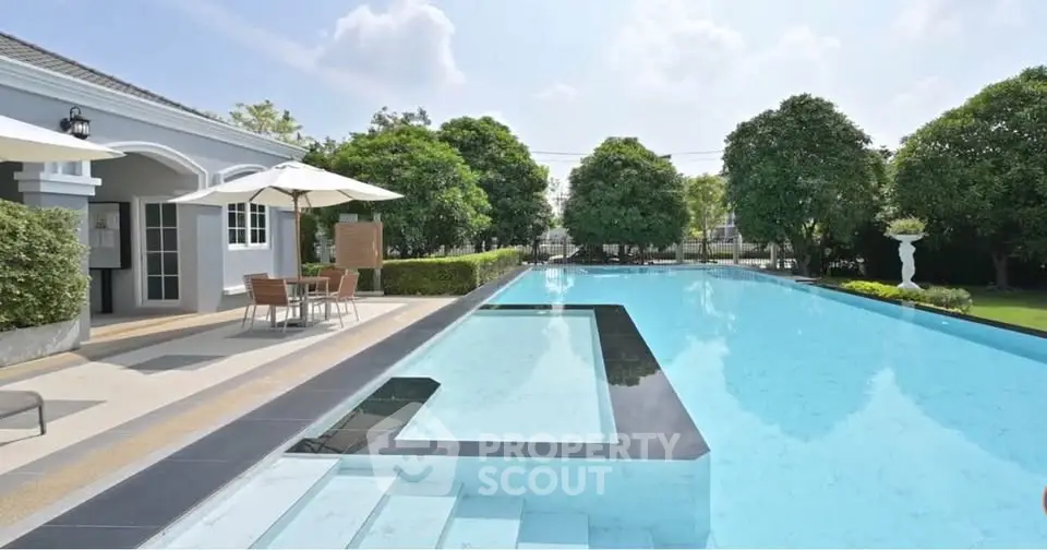 Luxurious outdoor pool area with elegant landscaping and seating, perfect for relaxation and entertainment.